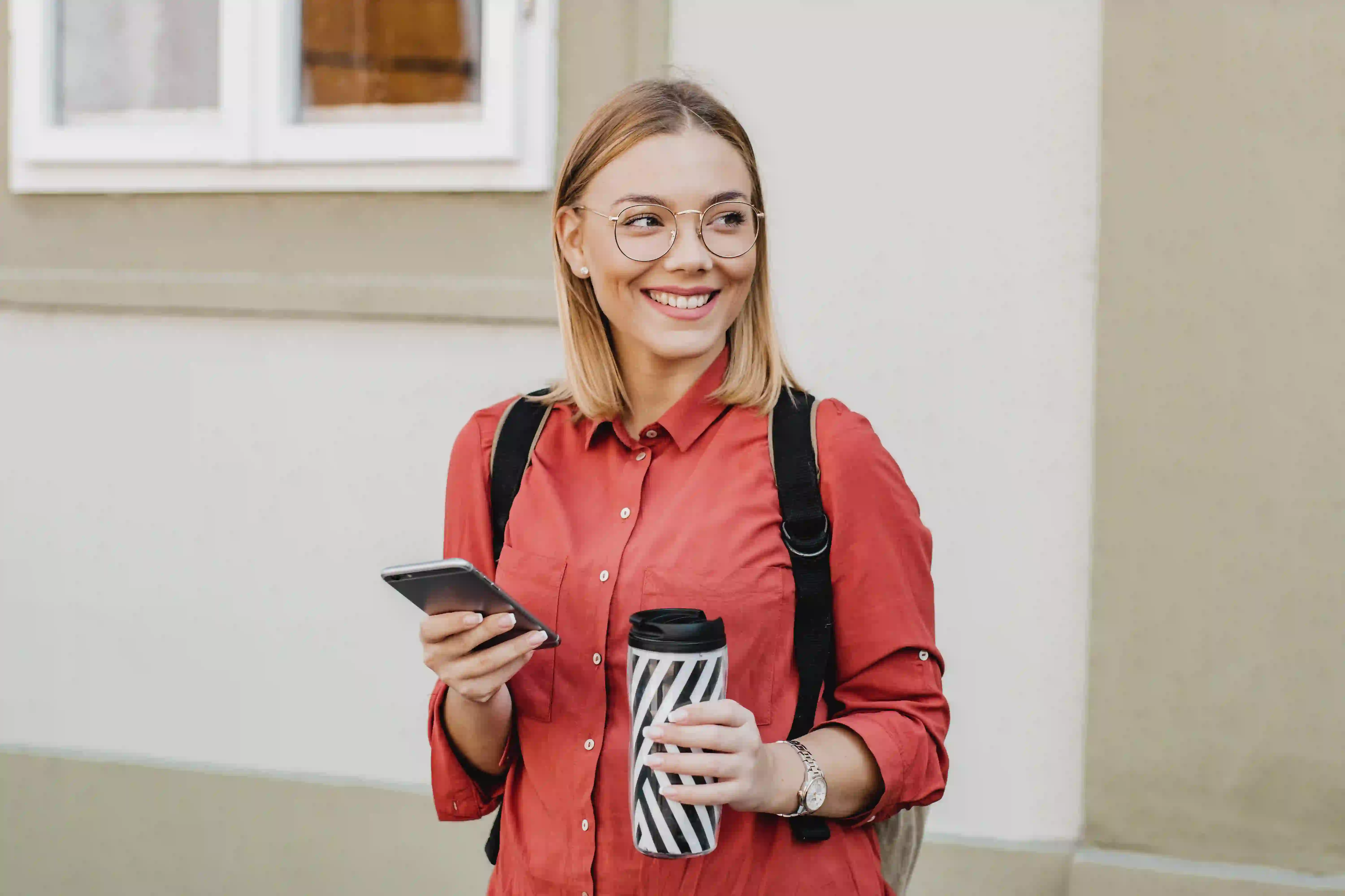 Bild junge Frau mit Handy und Kaffee