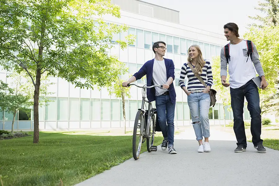 Bild drei Studierende mit Fahrrad